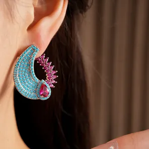 Close-up of a vintage teardrop earring with turquoise beads and pink zircons on ear.
