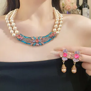 Dettaglio della collana di perle vintage e degli orecchini a fiore con perla a goccia.