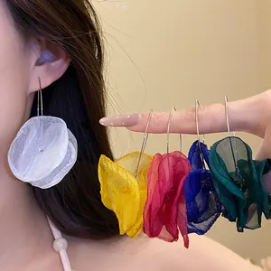 Detail view of colorful chiffon flower petal drop earrings worn by an Asian model