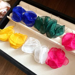 Macro view of colorful layered chiffon flower drop earrings displayed in jewelry tray