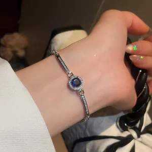 Detailed close-up of vintage silver bracelet with round blue stone and zircon on a wrist