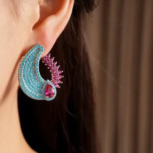 Close-up of a vintage-style turquoise and pink zircon water drop earring on an ear.