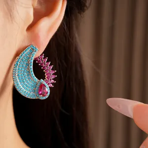 Macro detail of a vintage style teardrop earring with turquoise and pink zircons
