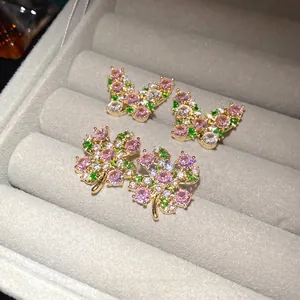 Vintage style gold butterfly and clover stud earrings with pink and green zircons.