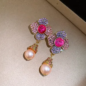 Vista macro dettagliata di orecchini a fiore vintage con strass rosa e pendenti di perle