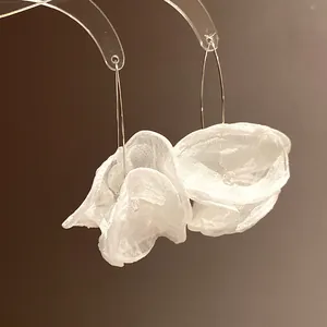 Detailed macro view showing the texture of delicate white chiffon flower drop earrings