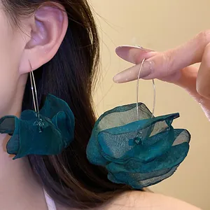 Close-up of dark green chiffon flower drop earrings showing the delicate petal texture.