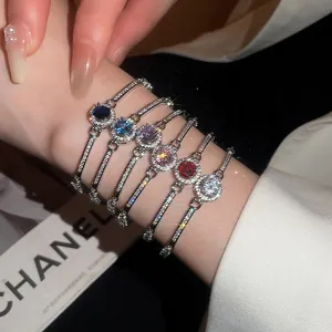 Macro view showing six colorful sparkly zircon round bracelets worn on a woman's wrist