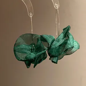 Close-up of elegant emerald green chiffon flower dangle earrings with long hooks