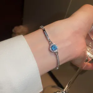 Detail view of a luxury round blue zircon bracelet sparkling on a woman's wrist