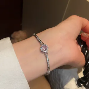 Detailed view of a vintage pink zircon round bracelet sparkling on a woman's wrist.