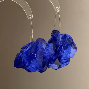 Macro view of delicate royal blue chiffon flower earrings with elegant fine wire hooks.