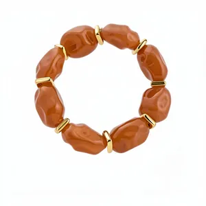 Chunky amber acrylic bracelet featuring irregular geometric beads and polished gold spacers