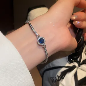Close-up of a vintage round blue zircon bracelet with shimmering stones on wrist.