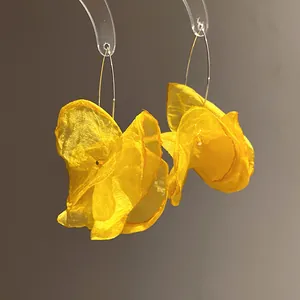 Detailed view of vibrant yellow chiffon flower drop earrings with silver hoops