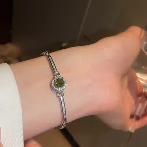 Close-up of vintage round green zircon bracelet with sparkling silver pave chain