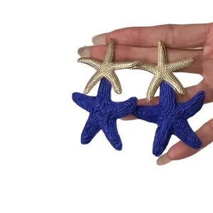 Bohemian beach style raffia starfish earrings with gold metal and deep blue woven texture