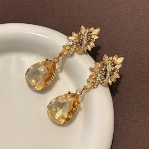 Vintage Baroque style amber crystal floral teardrop earrings on a white decorative plate