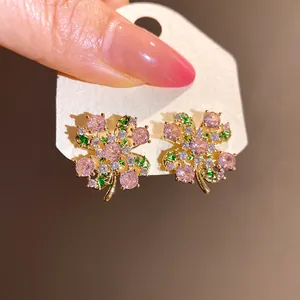 Detail of vintage style four-leaf clover earrings featuring pink and green zircon stones