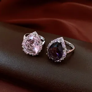 Makroaufnahme eleganter birnenförmiger Zirkonia-Ringe in Pink und Violett.