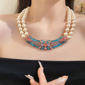 Primo piano di collana di perle vintage a due fili con ciondolo in strass colorati