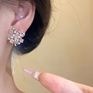 Detailed close-up view of an elegant vintage zircon clover stud earring worn on the ear