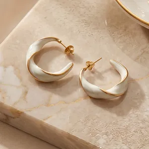 Dettaglio di orecchini a lobo a forma di C in smalto bianco intrecciato placcati oro 18K