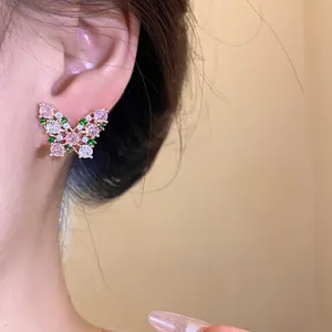Close-up detail of a sparkling zircon butterfly stud earring worn on a female ear