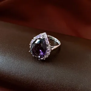 Detailansicht eines eleganten, lila Zirkonia-Rings in Birnenform mit Halo-Fassung