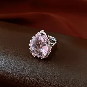 Detailaufnahme eines rosa Zirkonia-Rings in Birnenform auf braunem Lederhintergrund