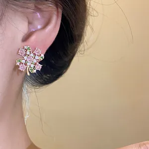 Elegant close-up of a pink zircon four-leaf clover stud earring worn on a human ear.
