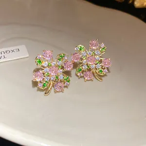 Close-up detail of elegant clover earrings with pink zircons and gold-tone finish
