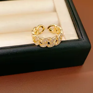 Close-up of gold chain link ring with pavé zirconia and an adjustable open band design.