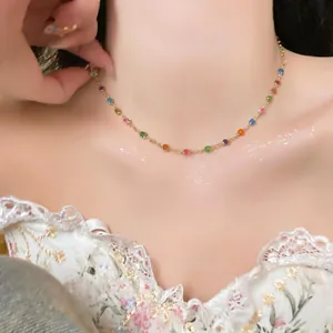 Detail view of a colorful resin round bead necklace on a woman as a dainty gold choker