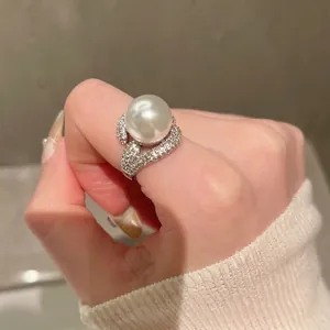 Elegant silver open ring with a large pearl and zircon accents in a luxury fashion style