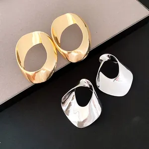 Detailed view of geometric hollow twisted earrings in elegant gold and silver finish