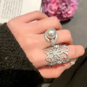 Elegant sterling silver finish zircon openwork flower ring and pearl ring on hand