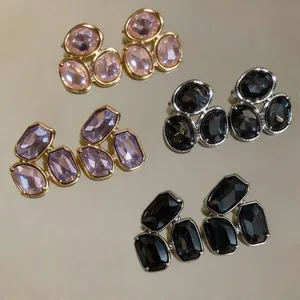 Gros plan de quatre paires de boucles d'oreilles élégantes en grappes de strass.
