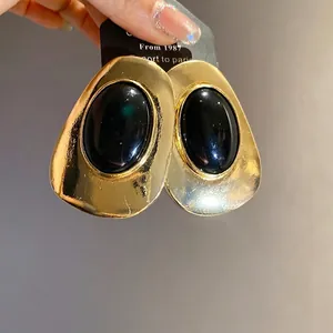 Retro oversized oval stud earrings with gold metal frame and black resin inlay design