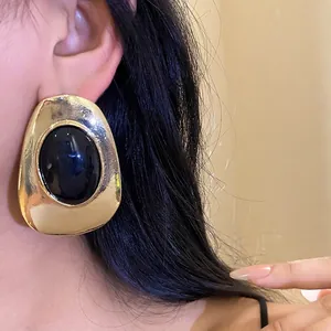 Vintage gold-tone metallic oval stud earrings with black resin inlay for a luxury look.