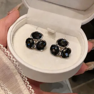 Boucles d'oreilles élégantes en cristal gris fumé dans un écrin blanc
