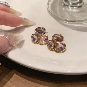 Gros plan détaillé de boucles d'oreilles élégantes en alliage doré avec trois grands cristaux
