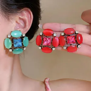 Detailed view of vintage-style earrings featuring cat-eye stones and shiny rhinestones.