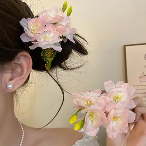 Détail de barrettes à fleurs en tissu rose portées et tenues par un mannequin élégant