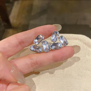 Vue détaillée en gros plan de boucles d'oreilles clous en strass violet géométrique