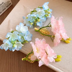 Vue détaillée de pinces à cheveux artisanales en tissu floral rose tendre et bleu pastel
