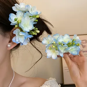 Gros plan de barrettes à fleurs en tissu bleu et blanc portées sur le côté