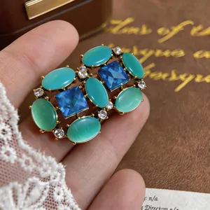 Close-up of vintage cat eye stone and blue crystal earring with gold setting