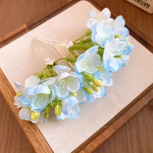 Gros plan détaillé d'épingles à cheveux en fleurs de tissu bleu et blanc sur fond de lin