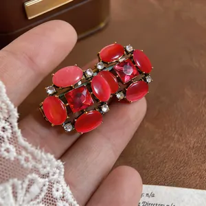 Detailed macro view of vintage red cat eye stone jewelry with crystals and gold metal finish
